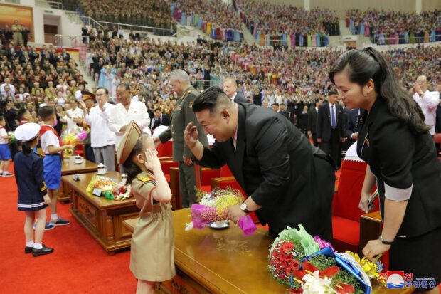 North Korean leader Kim Jong Un greets children as he attends a performance, in this image released by North Korea's Korean Central News Agency on July 27, 2023. KCNA via REUTERS