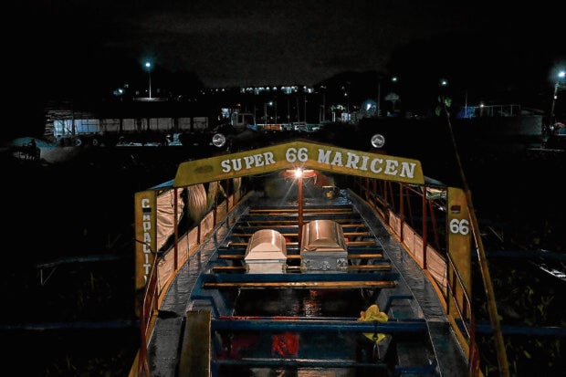 This photograph shows coffins of victims of the capsized wooden boat at Binangonan Port, Rizal province early on July 28, 2023. A small boat capsized in a lake near the Philippine capital on July 27, 2023, killing 23 people on board and leaving six others missing, rescuers said. (Photo by JAM STA ROSA / AFP)